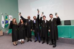 Novos defensores públicos posam com suas carteiras funcionais ao final da cerimônia de posse. 