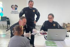 Servidores do Instituto de Identificação realizam a coleta de digitais para realização da identidade de uma mulher idosa que reside no Pequeno Cotolengo. 