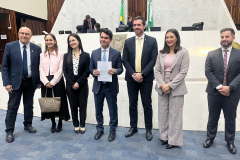 Imagem com a foto de representantes da Defensoria na Assembléia Legislativa do Paraná, junto do deputado Alezandre Curi, para entrega de projeto de Lei