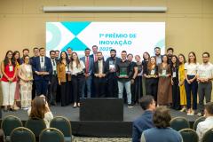 Premiados no concurso de inovação da Defensoria posam para foto no palco do evento. 
