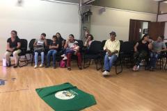 Roda do encontro com os faxinalenses, com a bandeira da comunidade estendida no meio da roda.
