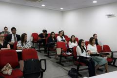 Na imagem vemos os novos defensores sentados prestando atenção em algo que lhes é dito/mostrado a frente. 