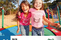 #LegendaAcessível: A imagem apresenta duas crianças abraçadas e felizes pulando em uma cama elástica com pinheiros e um lindo céu azul de fundo.

No rodapé no canto esquerdo a data 24 Agosto, Dia da Infância e no canto direito a logo da DPE-PR