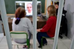 Detenta assiste a vídeo com depoimento de familiares durante encontro com equipe técnica da Defensoria Pública do Paraná.
