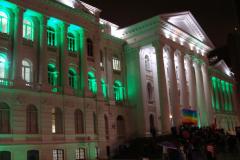 Fachada da Universidade Federal do Paraná iluminada de verde, a cor que simboliza a Defensoria Pública.