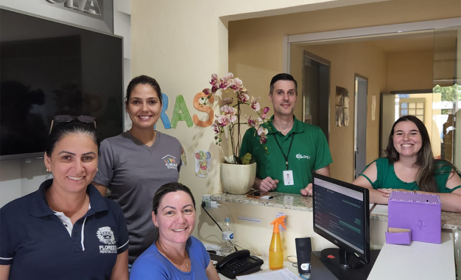 Imagem do grupo de pessoas que realizou o atendimento no mutirão em Floresta. Entre as pessoas estão um homem branco com a camiseta verde com o logo da Defensoria em branco, uma mulher branca com uma camisa verde e três servidoras do CRAS, todas brancas com camisetas da azuis.
