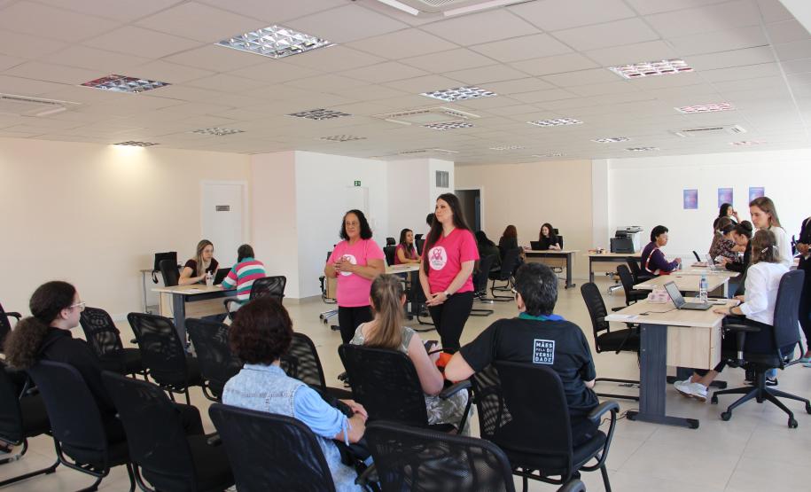 Imagem de representantes do coeltivo Amigas da MAMA em fala às usuárias