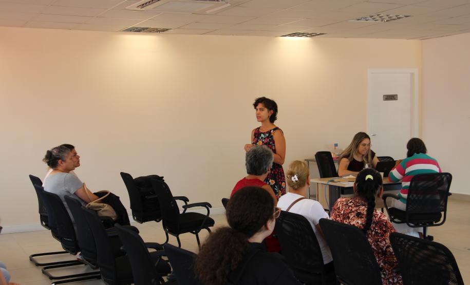 imagem de uma mulher palestrando para as usuárias que aguardam atendimento