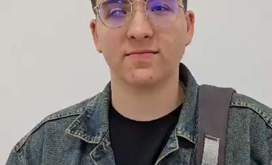 Imagem que mostra o entrevistado Diego Sikorski. Ele usa óculos, jaqueta jeans e carrega uma mochila.