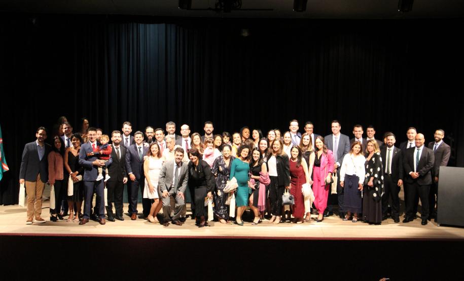 Imagem que mostra todos os defensores e defensoras presentes na cerimônia no palco do auditório.