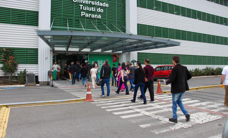 Imagem que mostra candidatos e candidatas entrando no prédio principal da Universidade Tuiuti, em Curitiba, um dos locais de prova.