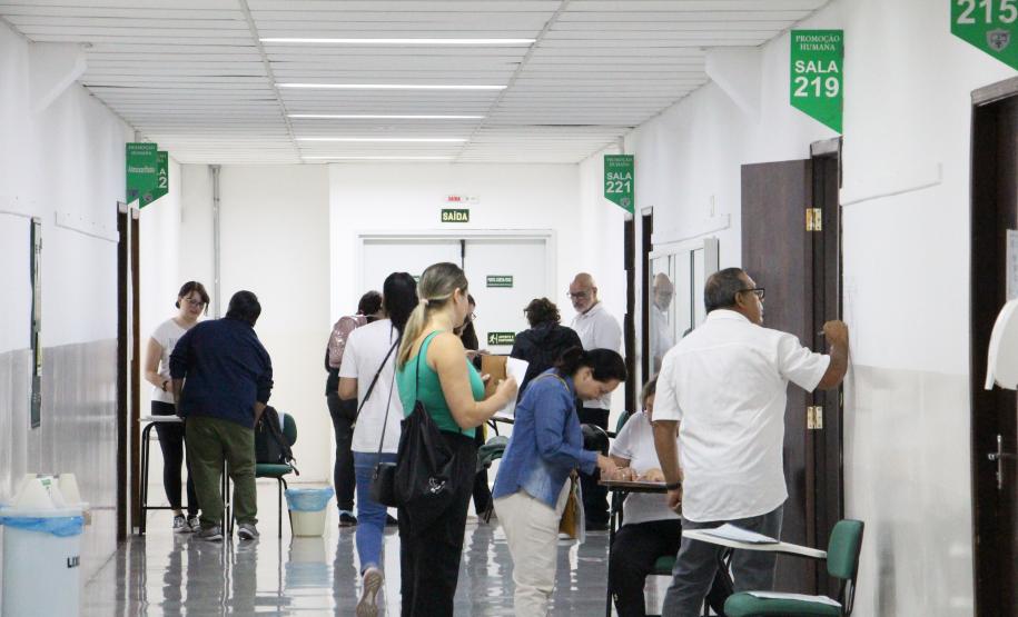 Imagem que mostra a entrada de candidatos e candidatas em salas de aplicação de prova do concurso.