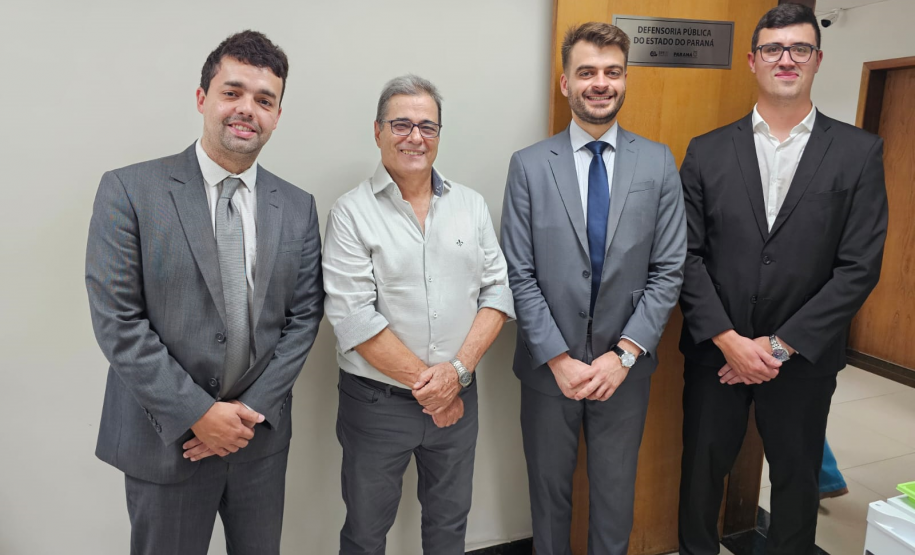 Imagem que mostra a inauguração da sala da DPE-PR em Cruzeiro do Oeste. Representantes da Defensoria posam em frente à porta da sala da DPE-PR, do lado de dentro da sala.