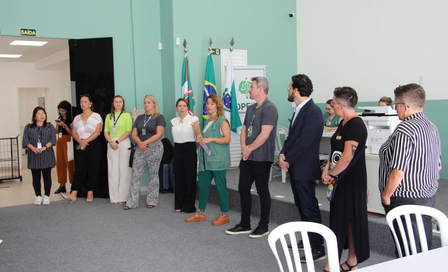 Imagem de uma foto com um ângulo aberto de defensores públicos e servidores públicos falando em pé.