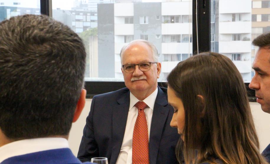 Imagem com a foto do Ministro Fachin sentado à mesa com personalidades representantes das catergorias da Defensoria.