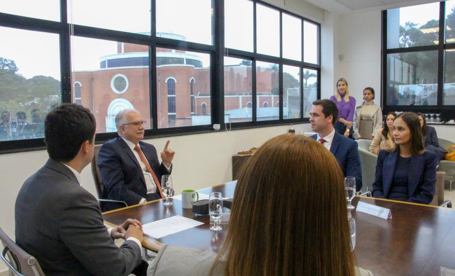 Imagem com a foto do Ministro Fachin sentado à mesa com personalidades representantes das catergorias da Defensoria.