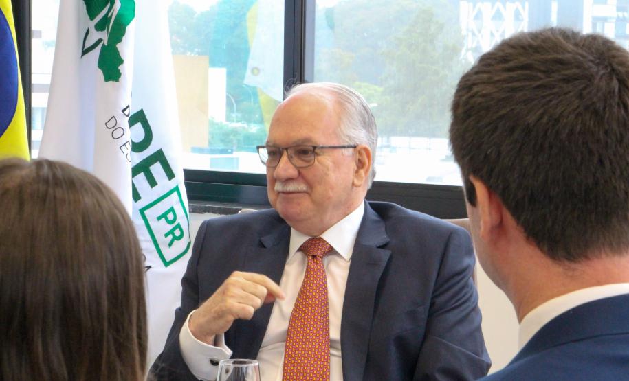 Imagem com foto do Ministro Fachin sentado à mesa junto de membros da isntituição