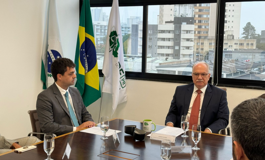Imagem com a foto do Ministro Fachin sentado à mesa ao lado do Defensor Público-Geral, André outras personalidades representantes das catergorias e setores da Defensoria.