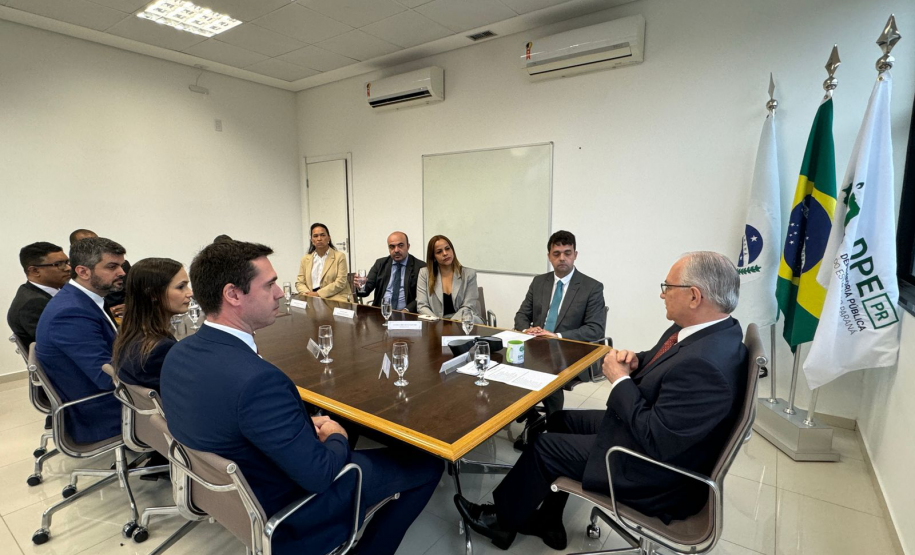 Imagem com a foto do Ministro Fachin sentado à mesa com personalidades representantes das catergorias da Defensoria.