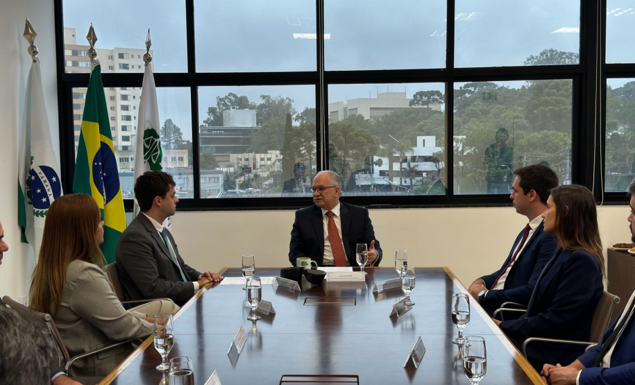 Imagem com a foto do Ministro Fachin sentado à mesa com personalidades representantes das catergorias da Defensoria.