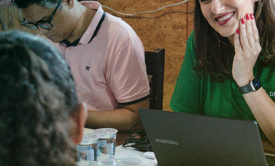 Foto colorida vertical em que se vê a equipe da Defensoria Pública prestando atendimento à população da Comunidade 29 de Março.