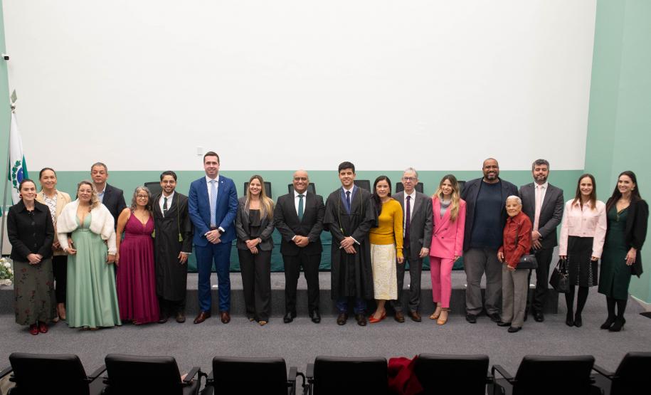 Imagem horizontal colorida em que se vê todos os presentes na cerimônia de posse dos Novos Defensores posando juntos no auditório.