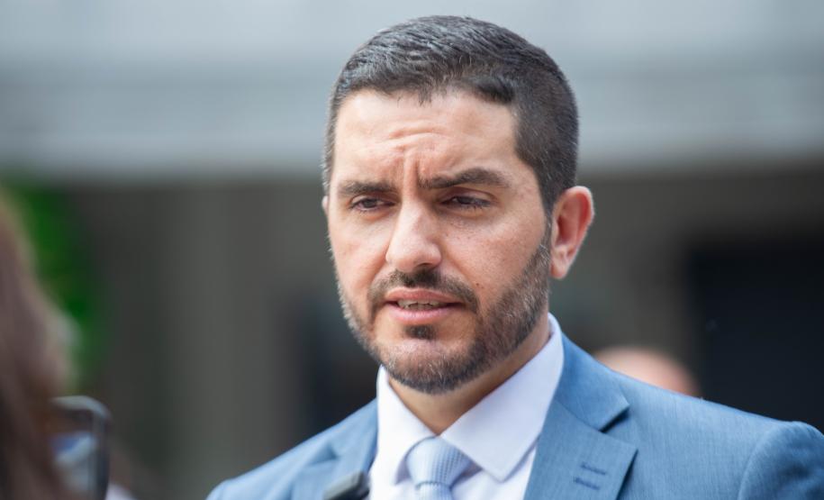 Imagem horizontal colorida em que se vê o Defensor Rafael Matos Souto responsável pelo Posto de Atendimento da Câmara Municipal de Curitiba.