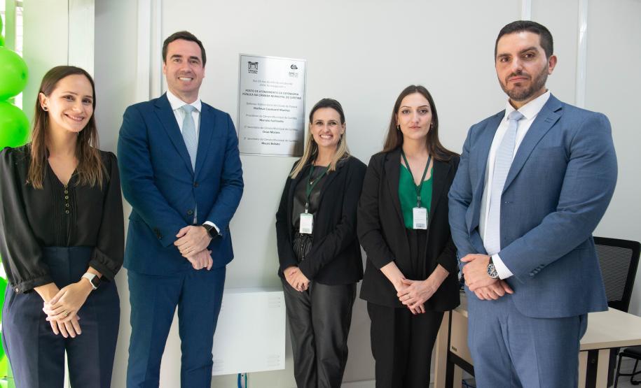 Imagem horizontal colorida em que se vê a equipe do novo Posto de Atendimento da DPE-PR na Câmara Municipal.