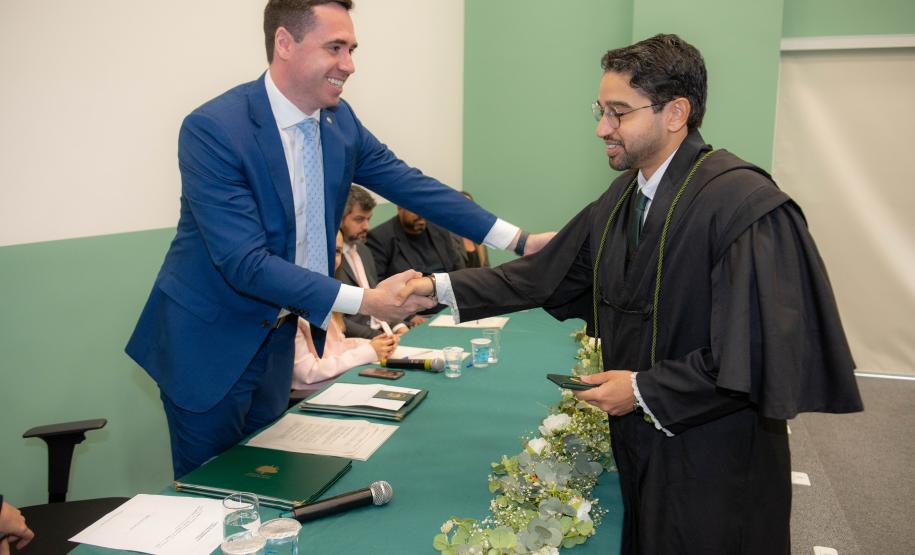 Imagem colorida em que se vê o Defensor Público Geral cumprimentando o novo Defensor Público empossando na cerimônia.