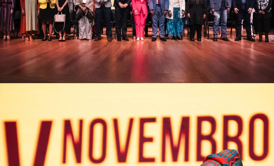 Duas fotos coloridas sobre postas. Na de cima se vê as autoridades posando ao fim do evento e na debaixo uma mulher negra discursando.