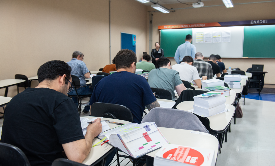Imagem horizontal colorida que mostra os candidatos realizando as provas.