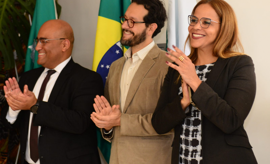 Imagem com defensores sorrindo e batendo palma durante a cerimônia