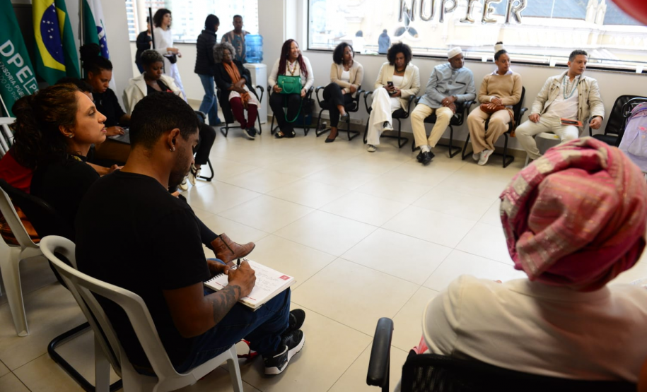 imagem com diversas pessoas representantes de coletivos negros sentados durante a roda de conversa com o NUPIER