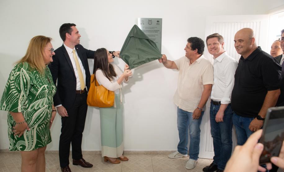 Foto colorida horizontal em que se vê autoridades descerrando a placa inaugural do Posto de Atendimento da DPE-PR em Matinhos.
