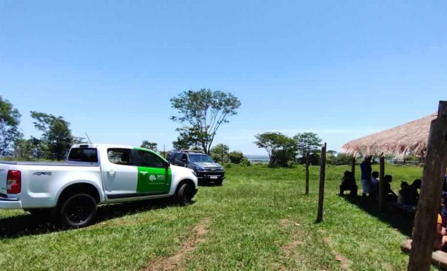 Imagem horizontal colorida em que se vê carro da DPE-PR próxima ao espaço comunitário da Aldeia Indígena em Guaíra.