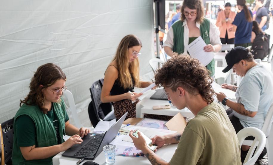 Imagem horizontal colorida em que aparece a equipe da DPE-PR realizando os atendimentos do Mutirão.