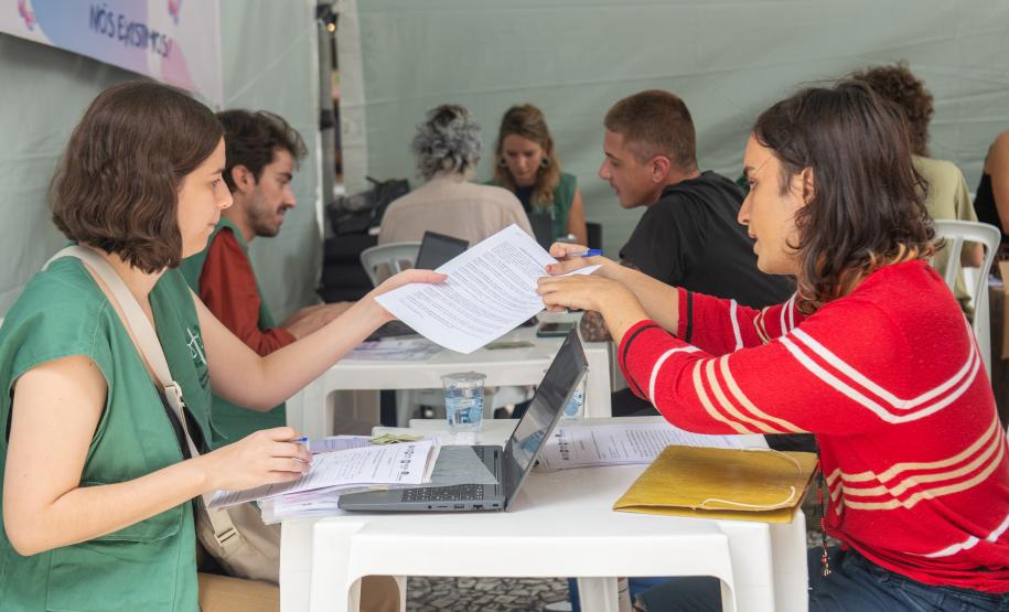 Imagem horizontal colorida em que aparece assistidos recebendo atendimento da DPE-PR durante Mutirão.