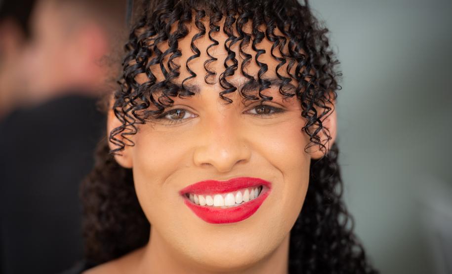 Imagem horizontal colorida em que aparece rosto sorridente de uma assistida ao fim do atendimento no Mutirão.