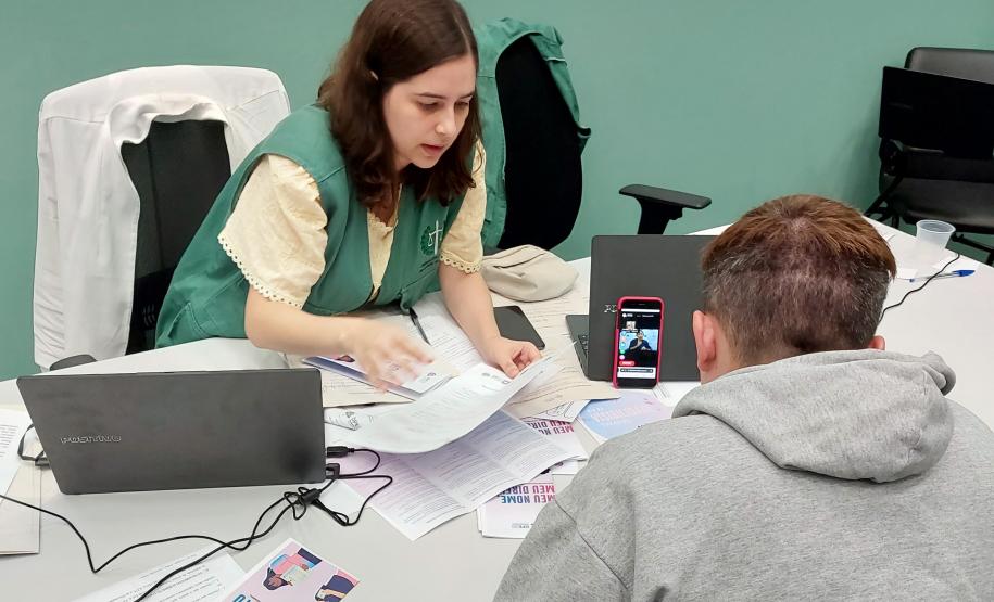 Imagem horizontal colorida em que se vê atendimento a assistido da DPE-PR realizado em Libras com plataforma online Icon