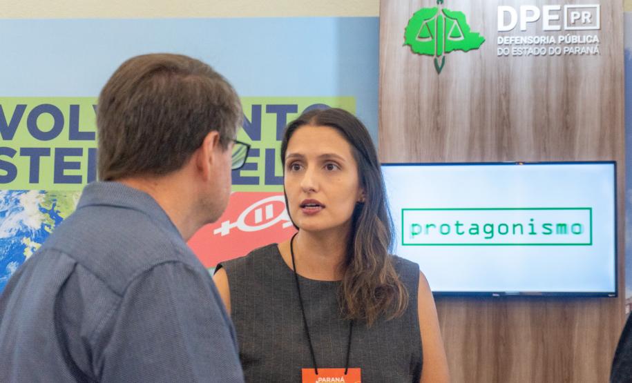 Imagem horizontal colorida mostra o estande da Defensoria Pública no evento Paraná Mais Cidades em Foz do Iguaçu.