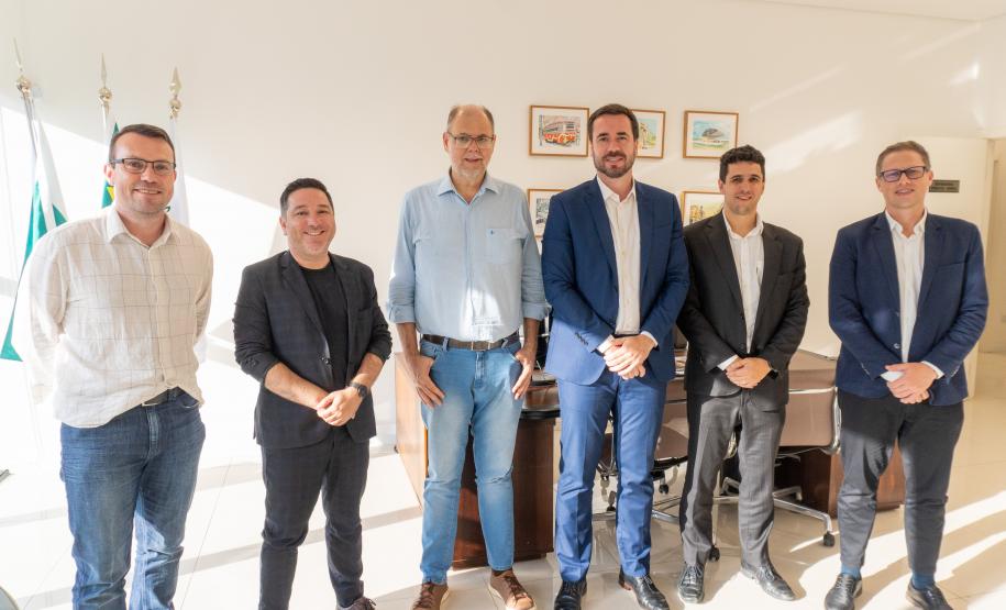 Imagem horizontal colorida mostra DPG e o Secretario Alex Canziani posando em pé.