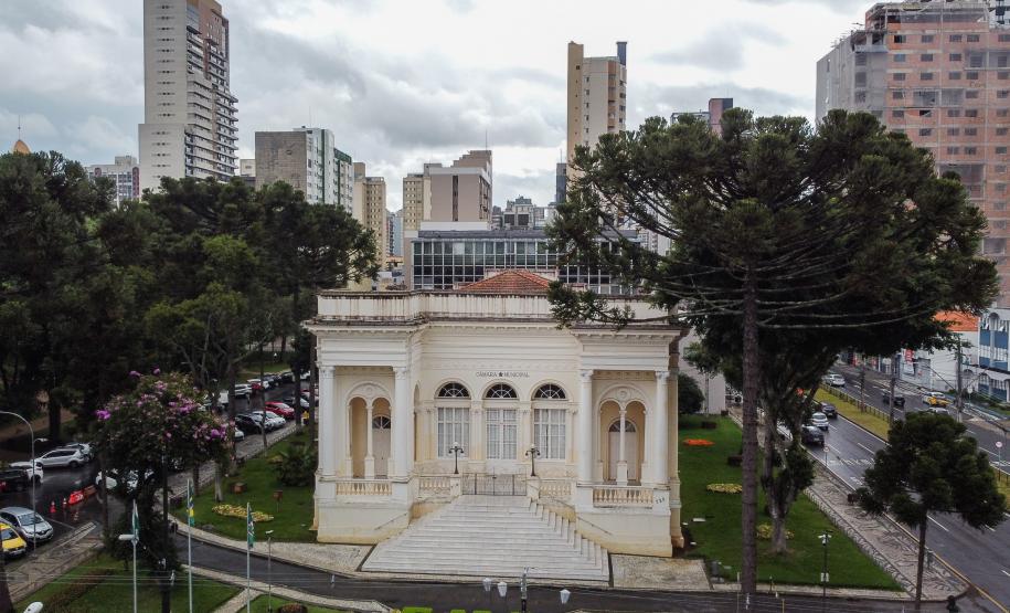 Imagem horizontal colorida mostra vista aérea da fachada da Câmara Municipal de Curitiba.