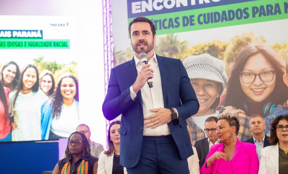 Imagem horizontal colorida em que se vê o DPG Matheus Munhoz discursando durante o lançamento do Projeto Ampara.