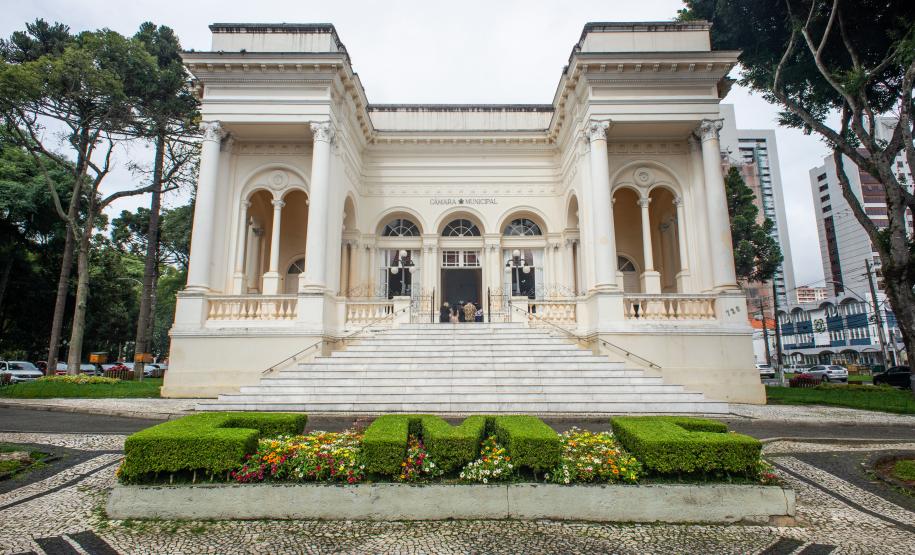 Imagem horizontal colorida mostra a fachada da Câmara Municipal de Curitiba.