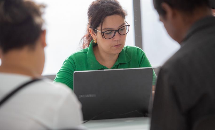 Imagem horizontal colorida em que se vê um casal assistido da Defensoria Pública chegando para o mutirão de conciliação realizado em Santa Felicidade.