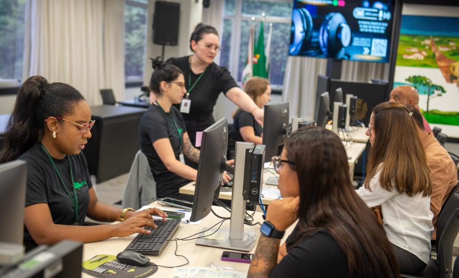 Imagem colorida horizontal em que se vê assistidos recebendo atendimento da DPE-PR em Mutirão realizado na Câmara Municipal de Curitiba.