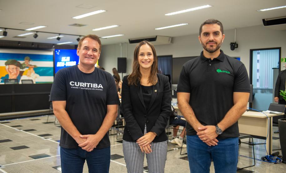 Imagem colorida horizontal em que se vê o presidente da Câmara Municipal, Tico Kuzma, a Subdefensora Geral Livia Brodebeck e o defensor público Rafael de Matos Souto durante Mutirão realizado na CMC.