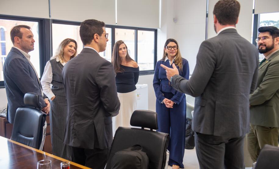 Imagem horizontal colorida em que se vê representantes das Defensorias Públicas do Paraná e do Pará em reunião na DPE-PR.