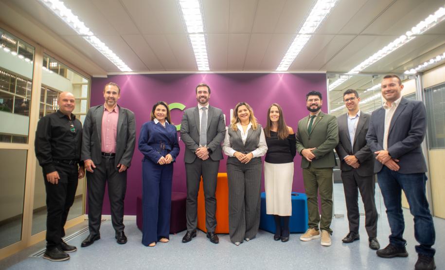 Imagem horizontal colorida em que se vê representantes das Defensorias Públicas do Paraná e do Pará em visita à Celepar.