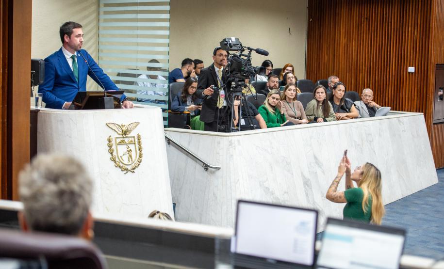 Em primeiro plano a mesa diretiva da ALEP-PR, ao fundo Defensor Público Geral discursa na Tribuna e representantes da instituição acompanham a sessão do primeiro balcão.